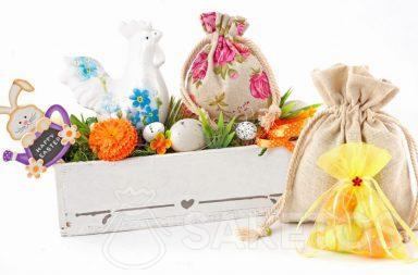 Una colorida composición de Pascua creada de bolsas de tela y una maceta rectangular con huevos de Pascua