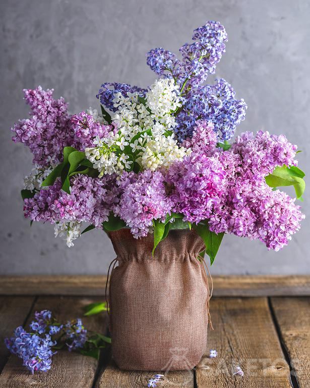 Flores lilas en un jarrón decorado con una bolsa de yute