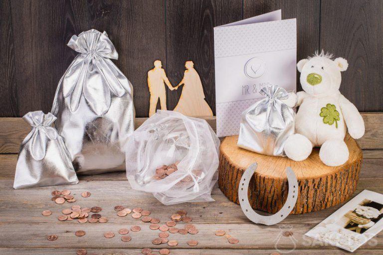 Cuando el regalo de bodas es dinero, puedes envasarlo en una hucha de cristal colocada en una bolsa de organza.