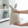 Bolsas de lino con un tierno conejito de peluche en su interior.