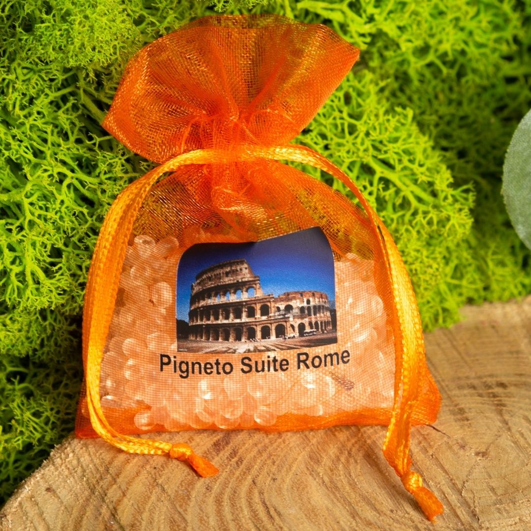 Bolsa de organza naranja con impresión del Coliseo, atada con una cinta.