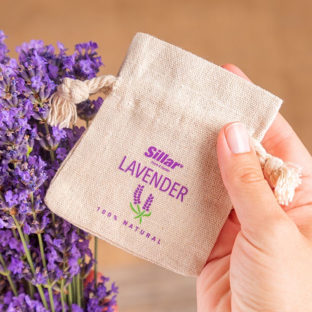 Bolsa de algodón con estampado de lavanda morada, sostenida en la mano.