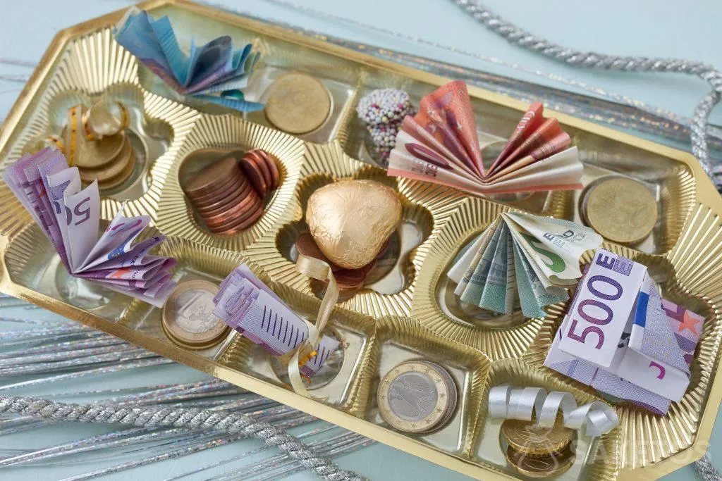Los billetes y monedas se pueden colocar en una caja de chocolate entre pralinés