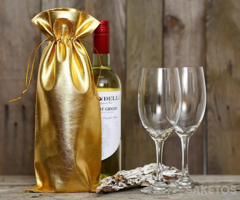Una botella de vino envuelta en una bolsa metálica dorada.
