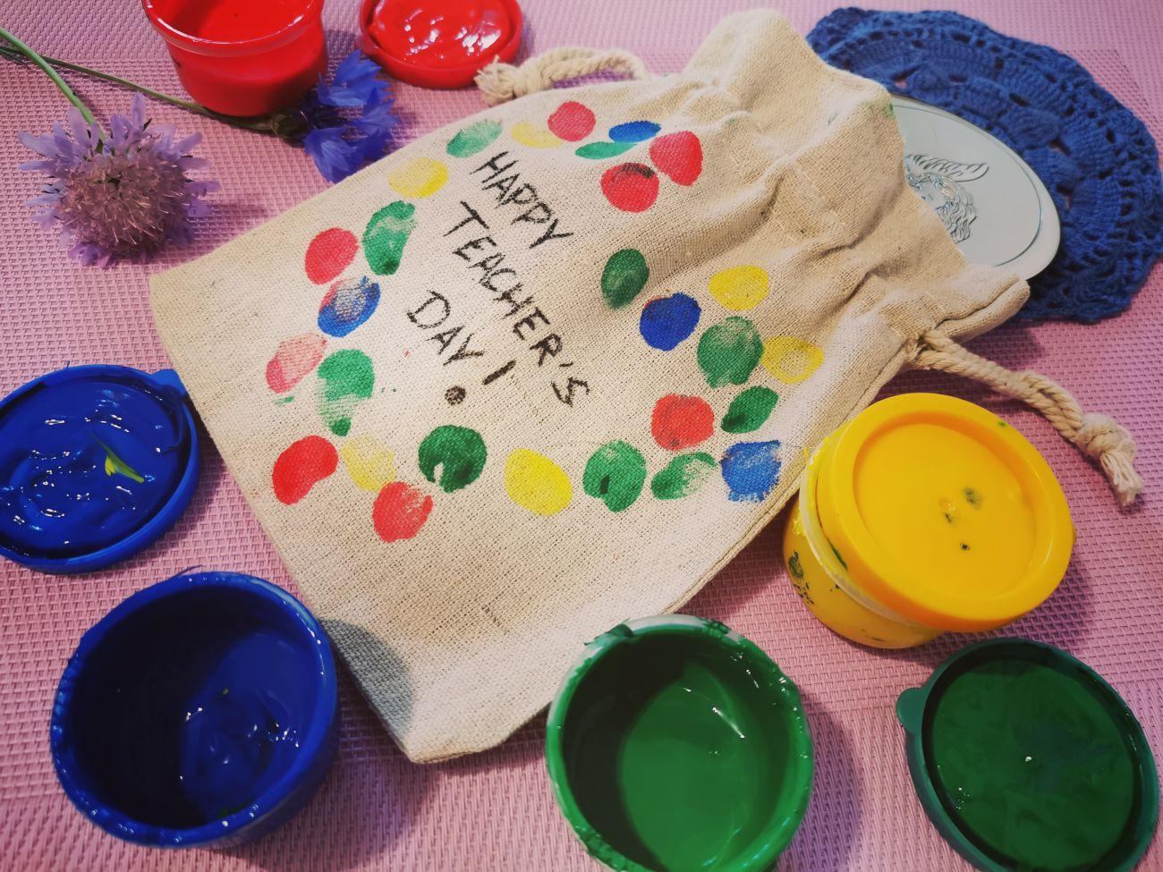Un regalo para un profesor en un bolso decorado con las huellas dactilares de sus alumnos