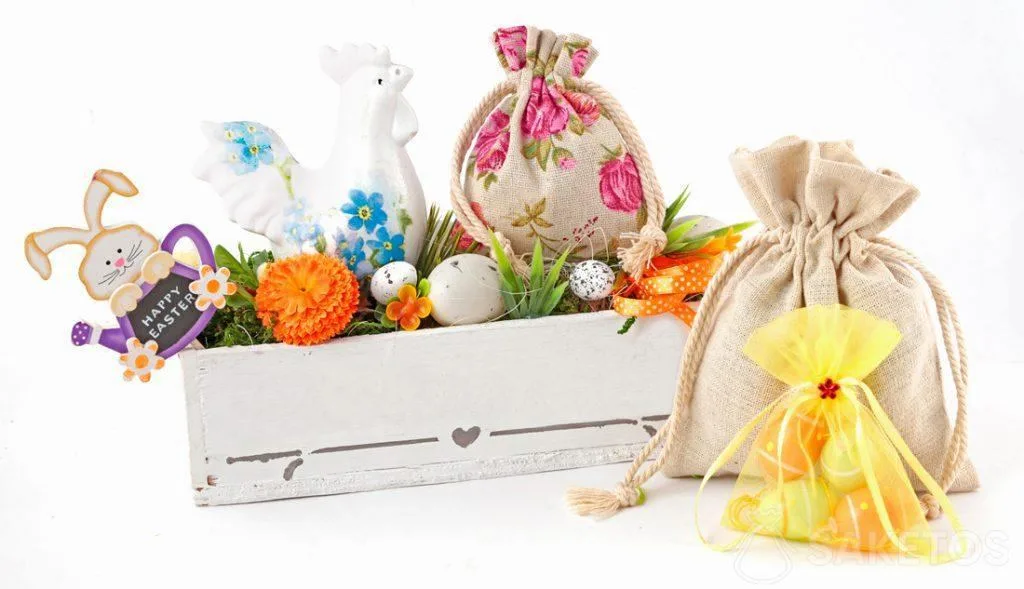 Una colorida composición de Pascua creada de bolsas de tela y una maceta rectangular con huevos de Pascua