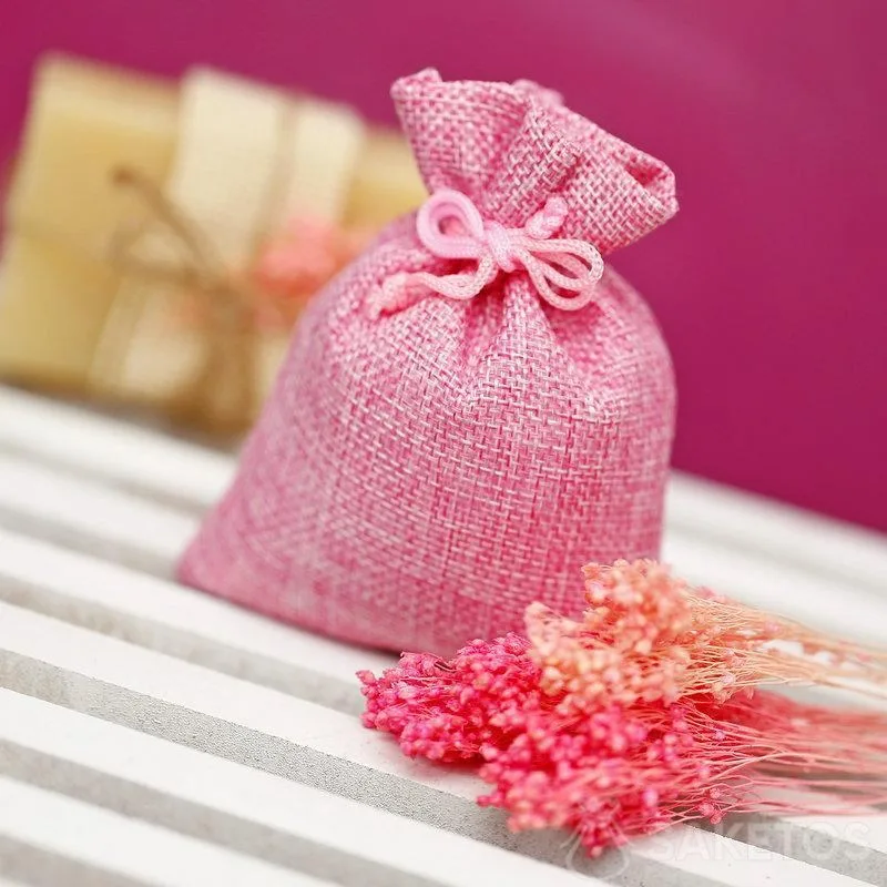 Bolsa de yute rosa para empacar una pastilla de jabón natural.