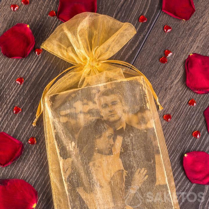Elegante y dorada bolsa de organza que sirve de envoltorio para la foto de los recién casados