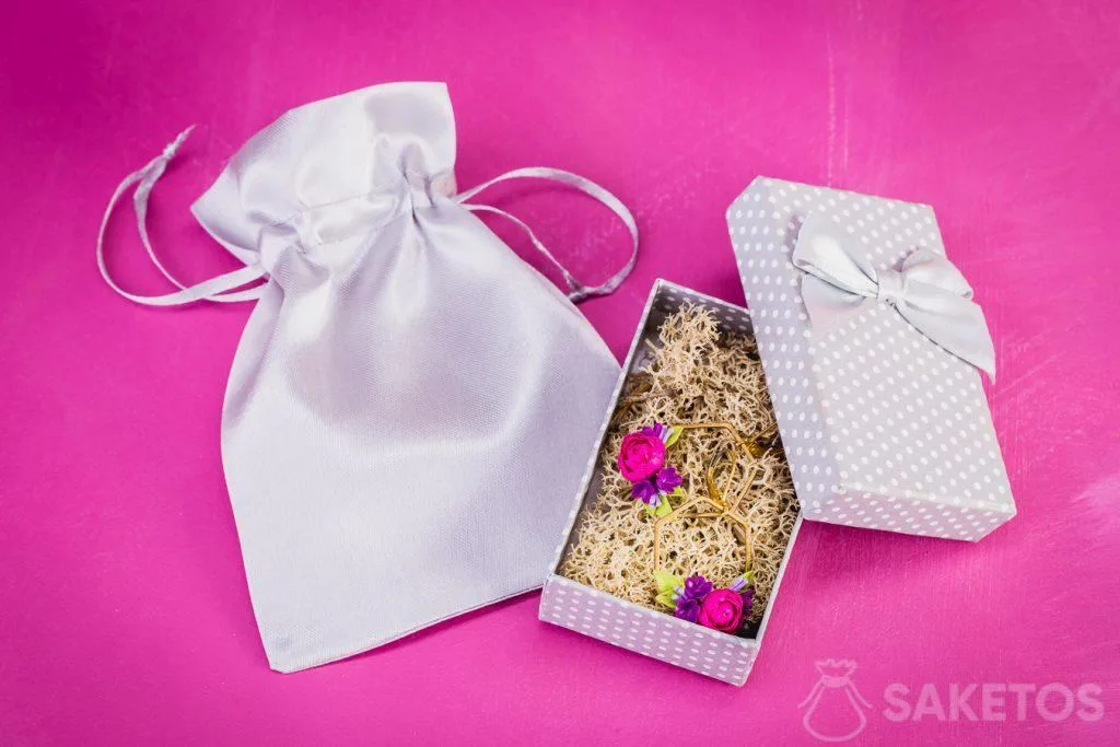 Pendientes envueltos para regalo en un joyero y una bolsa de satén