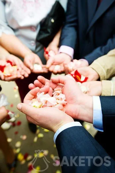 Los invitados a la boda esperan para bañar a los recién casados a la salida de la iglesia