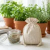 Bolsas de lino junto a hierbas en maceta y frasco de vidrio - almacenamiento y embalaje de regalo