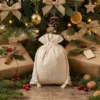 Bolsas de lino bajo el árbol de Navidad con decoraciones - embalaje festivo de regalos