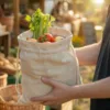 Bolsa de lino con verduras frescas y hierbas sostenida en las manos en una tienda ecológica