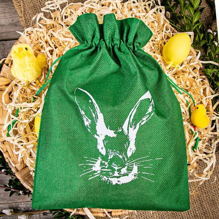 Bolsita de tela verde con dibujo de conejo blanco para dulces de Pascua.