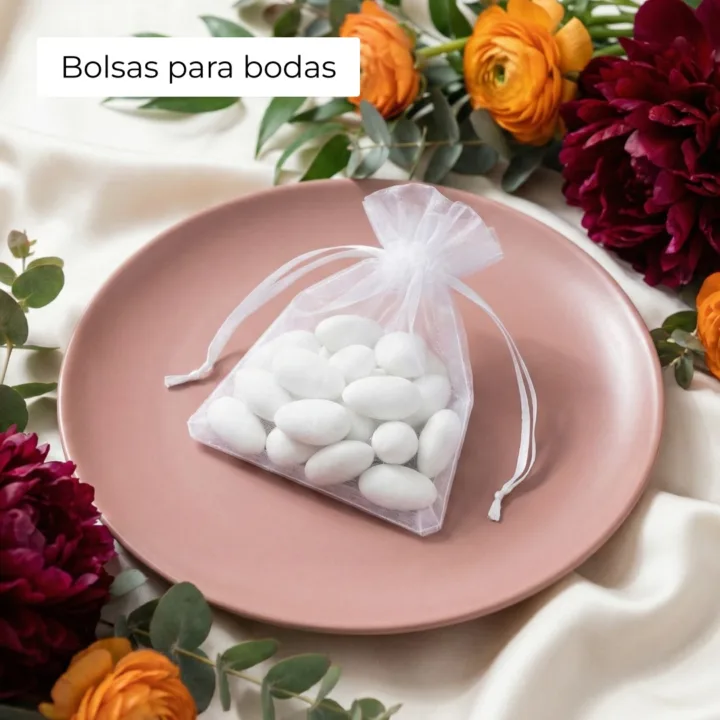 Saquito de organza blanco con almendras en un plato para detalles de boda.